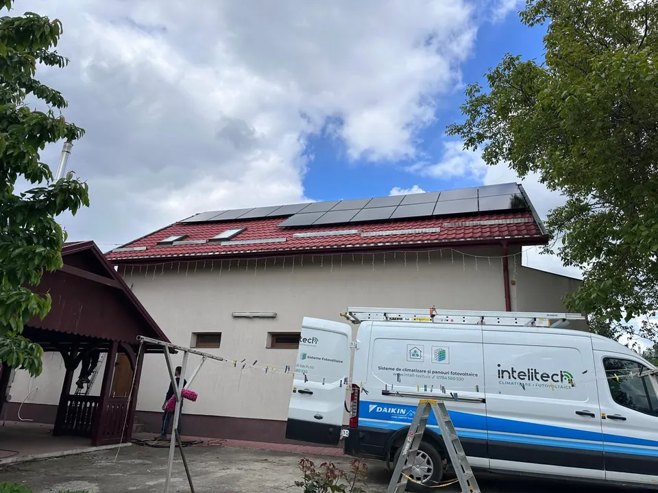 Echipa Intelitech la montajul unui sistem fotovoltaic pe o casă, cu autoutilitara firmei în față