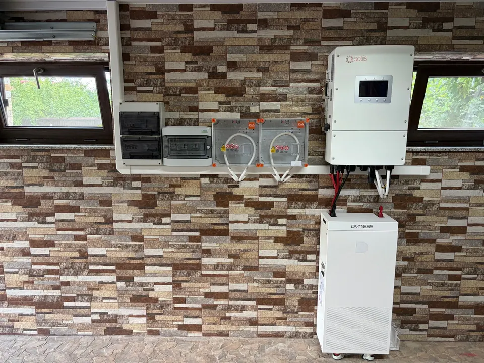 Invertor hibrid și acumulator montate pe perete, cu tablourile de protecție