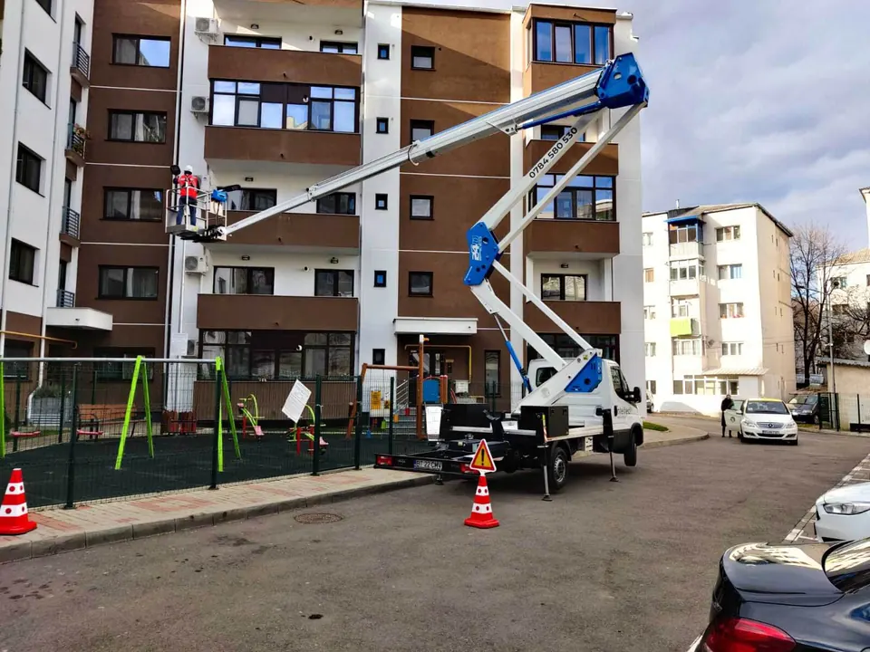 Nacelă Intelitech lucrând la fațada unui bloc de locuințe