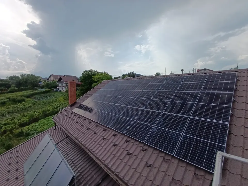 Panouri fotovoltaice pe un acoperiș din țiglă metalică maro